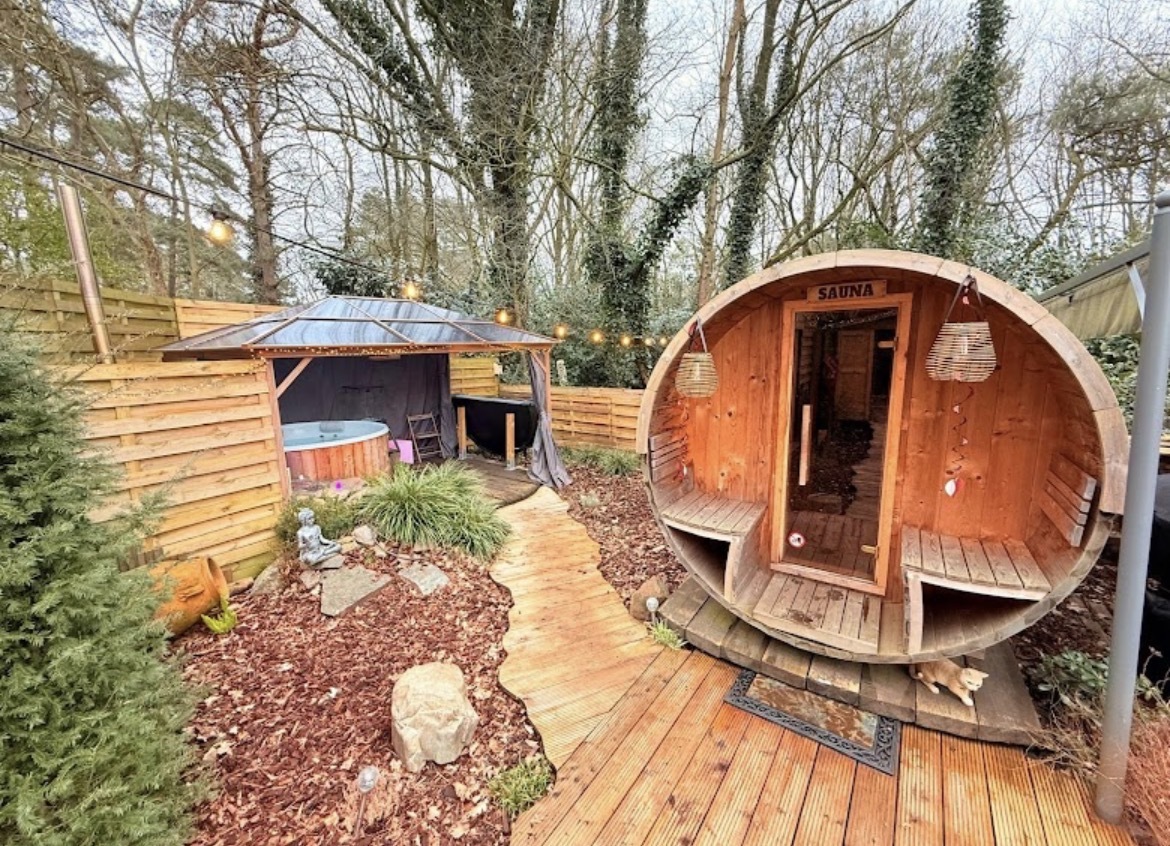 De tuin van Woodwellness met de tonsauna en de overdekte hottub